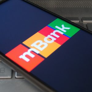 mBank bank logo displayed on the screen of a smartphone - lying on a laptop keyboard. The era of electronic banking